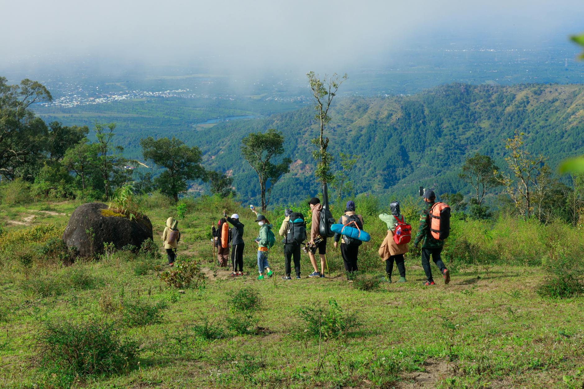 Turyści z plecakami idą górskim szlakiem w Beskidach przy ładnej pogodzie